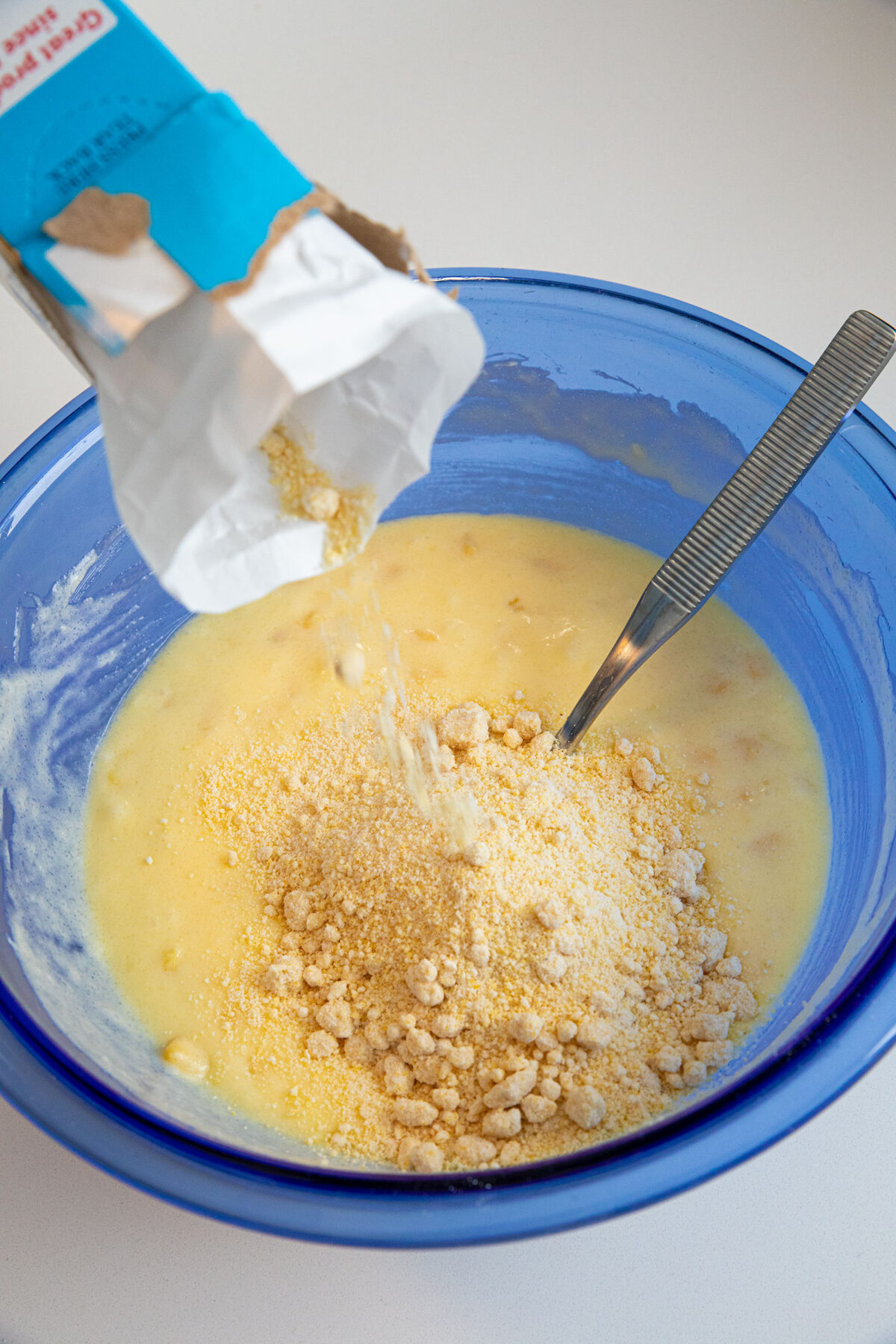 pouring Jiffy mix into batter 