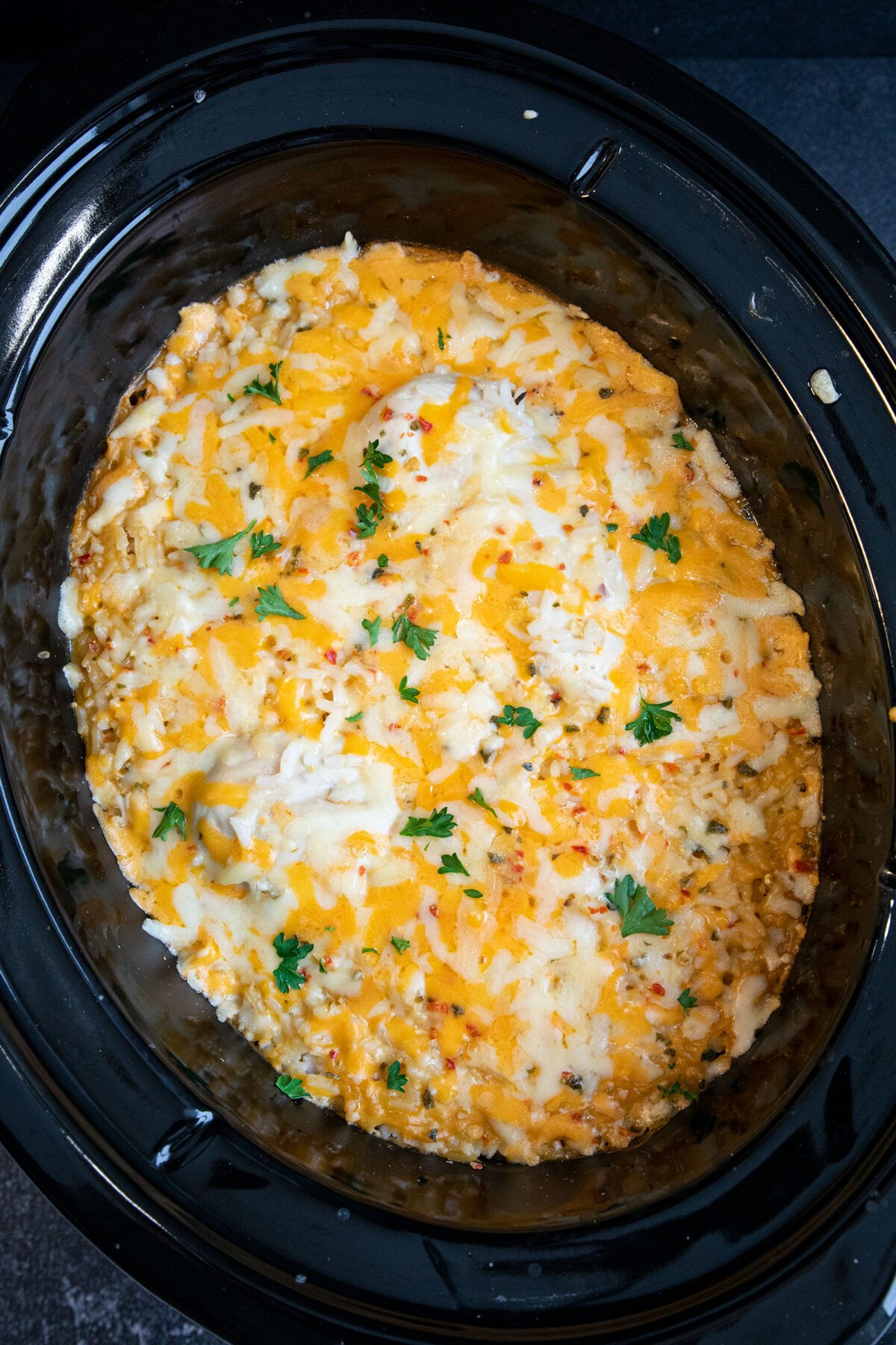 slow cooker full of chicken breasts and cheesy rice 