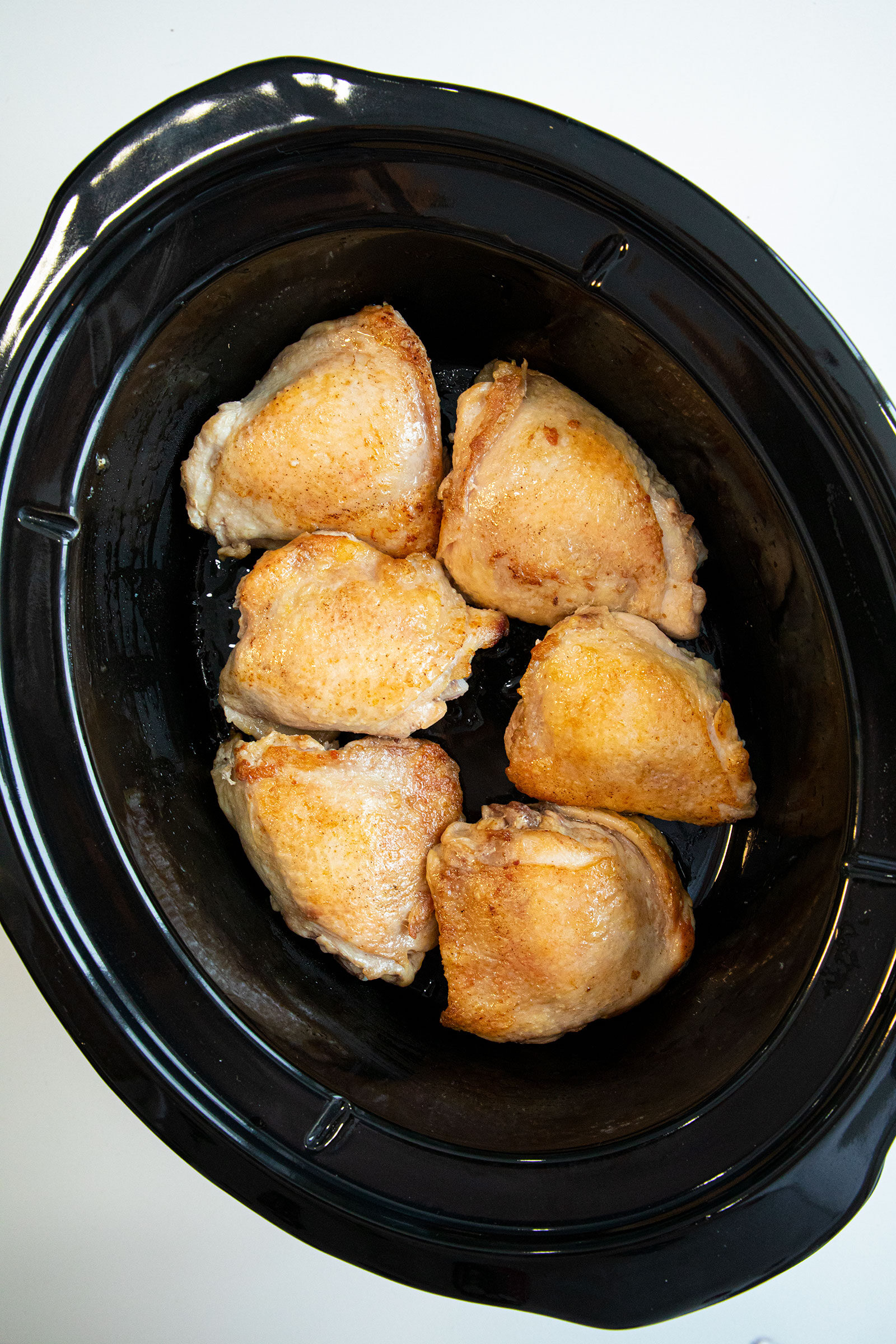 chicken thighs in a slow cooker ready to cook