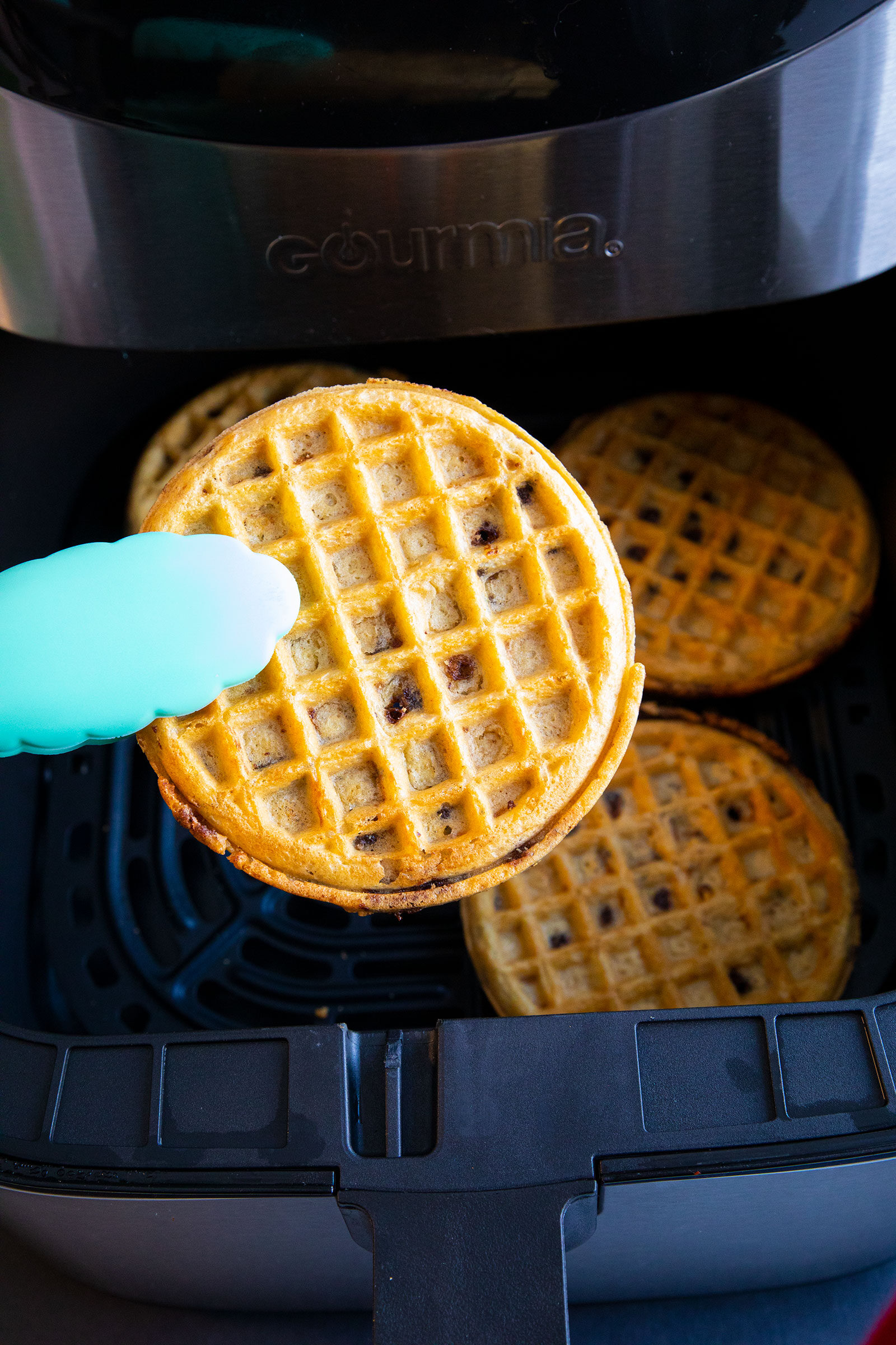 frozen waffle between a pair of tongs