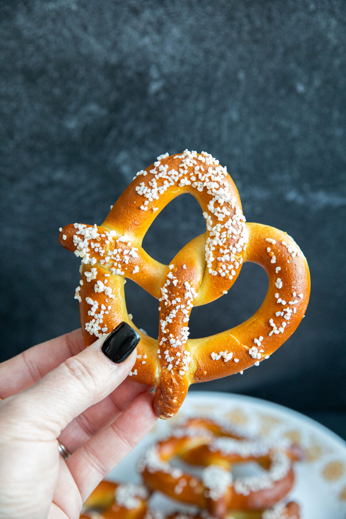 a hand holding a soft pretzel that was cooked in an air fryer 