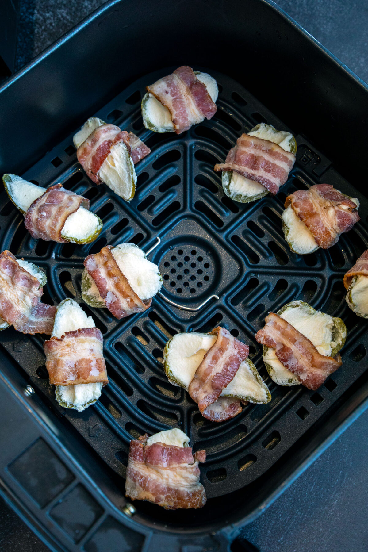 frozen bacon wrapped jalapeños in the air fryer basket