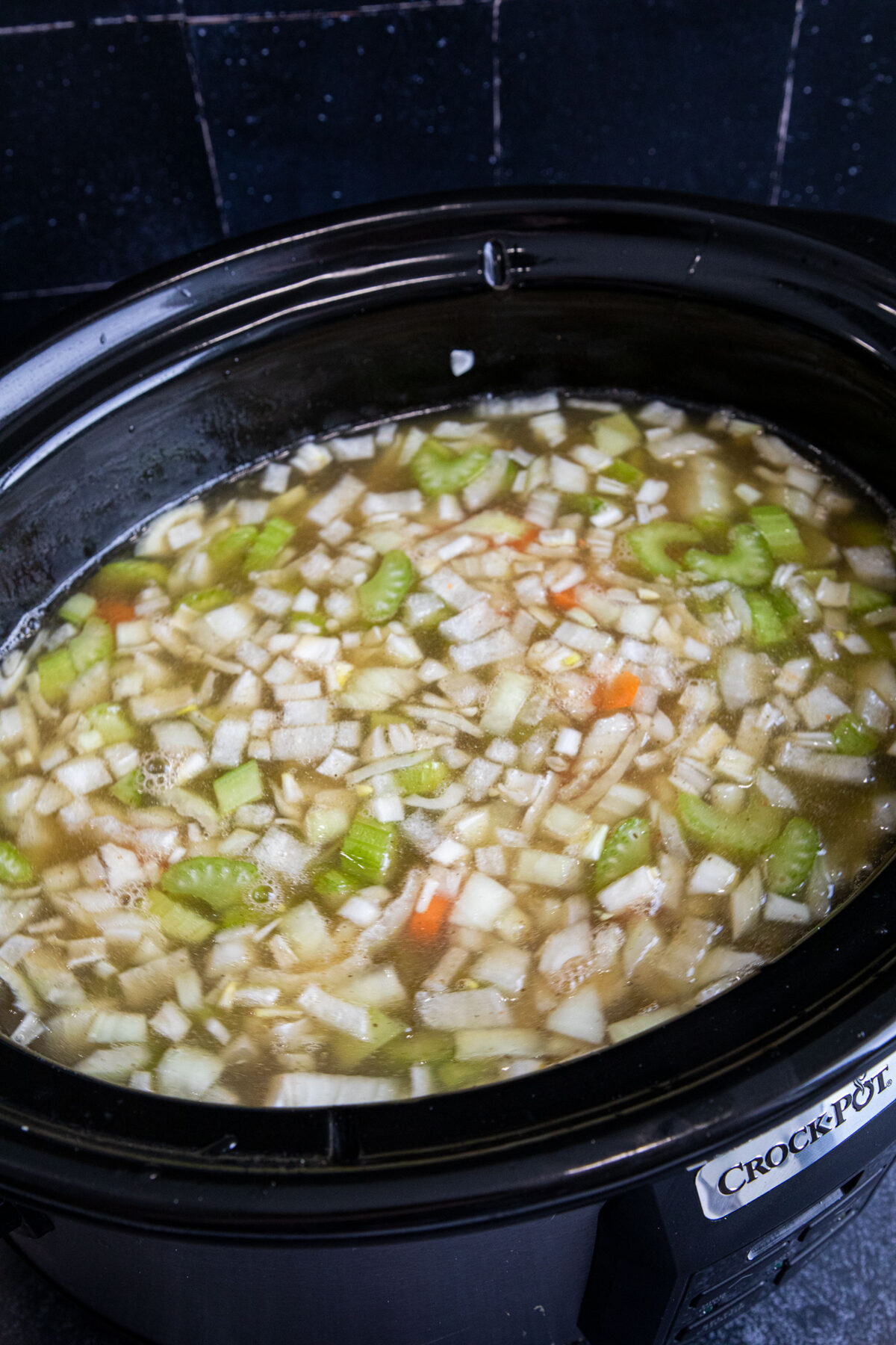Slow Cooker chicken noodle soup in a black crock pot