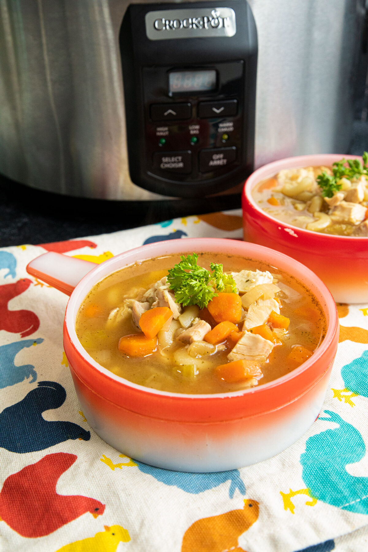 Slow Cooker chicken noodle soup in a red bowl 
