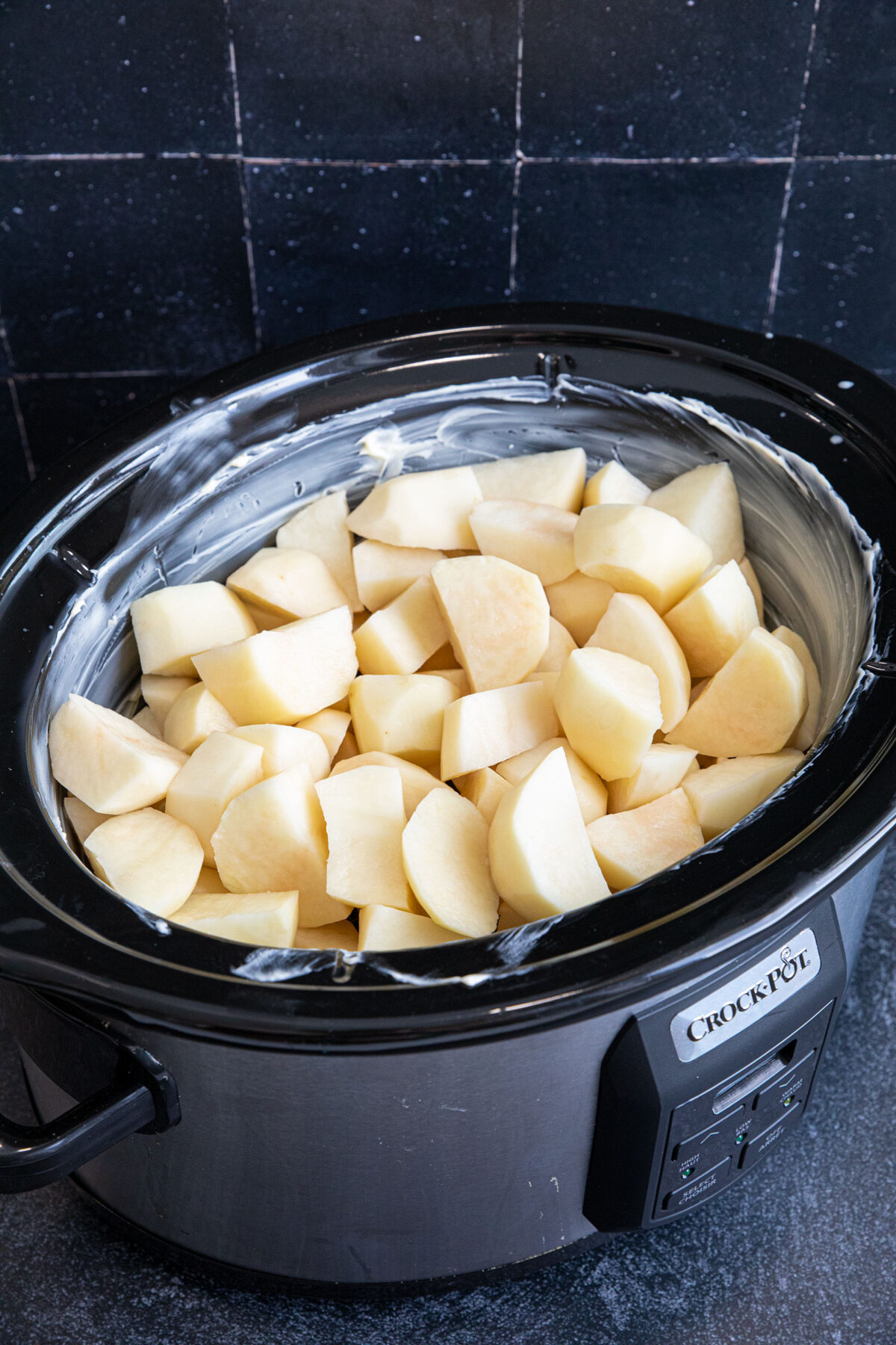 chopped potatoes in a buttery slow cooker 